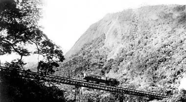 Trem do Corcovado cruzando um viaduto na encosta da floresta, foto histórica em preto e branco